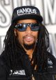 Lil' Jon wearing a "FAMOUS" cap and sunglasses, showcasing his signature style at a music event.