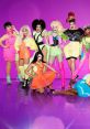 Colorful group of drag queens in vibrant outfits posing confidently against a bright purple backdrop, showcasing fierce drag style.