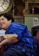 Josh happily playing guitar in a colorful shirt from "Drake and Josh," showcasing a lighthearted, fun moment.