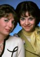 Laverne and Shirley share a cheerful moment, showcasing their iconic 70s fashion and playful friendship.