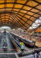 Modern train station interior with multiple tracks, trains, and an impressive architectural ceiling design.