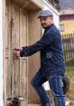 Man unlocking a rustic wooden door, embodying the concept of 'porta destrancando’ in a serene outdoor setting.