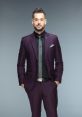 Mike Rome showcases a stylish purple suit, exuding confidence with a sharp look and a poised stance. Perfect for events.