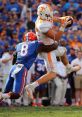 Tennessee receiver makes a catch while being tackled by Florida defender during a college football game. Florida vs. Tennessee clash.