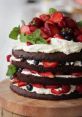 Delicious chocolate cake layered with whipped cream and topped with fresh strawberries, raspberries, and blueberries.