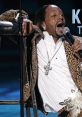 Katt Williams performing passionately in leopard print, showcasing his vibrant style and charisma on stage.