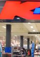 Bright Kmart signage in a well-lit store showcasing retail shelves and shopping carts for a vibrant shopping experience.