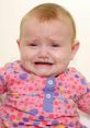 Crying baby with sad expression, wearing a colorful polka dot shirt. Evokes emotions and relatable moments of childhood sadness.