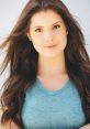 Amanda Cerny showcases her natural beauty with long, flowing hair in a relaxed blue t-shirt, exuding confidence and charm.