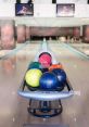 Colorful bowling balls neatly arranged on a rack with bowling lanes in the background, ready for play.