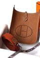 Hermès brown leather bag with perforated logo and strap, elegantly presented in an orange box for luxury fashion lovers.