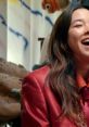 Smiling female host in a striking red blazer, featuring colorful art in the background, on set of the Choe Show.