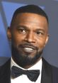 Jamie Foxx with a stylish tuxedo, showcasing his iconic smile and confidence at a formal event.