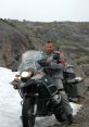 Rider on a BMW motorcycle navigating rocky terrain with snow, ready for adventure and exploration in the wilderness.