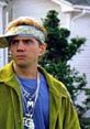 Character from "Malibu's Most Wanted" sporting a bandana, necklace, and green jacket, embodying comedic street style.