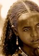 Portrait of an Ethiopian girl with braided hair and traditional jewelry, capturing the beauty of Amhara culture.