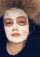 Young woman with a facial mask, wearing a furry hood, showcasing a skincare routine for healthy skin in the UK.