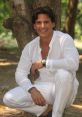 Jorge smiles charmingly while posing in nature, wearing a stylish white outfit, showcasing a relaxed Mexican vibe.