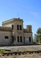 Historic abandoned building in Candela, Mexico, featuring distinctive architecture near railway tracks.