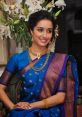 Young woman in elegant blue and purple saree, adorned with traditional jewelry, embodying Marathi cultural beauty.