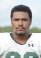 Portrait of a high school football player in a white jersey, showcasing determination and athletic focus at WDHS.