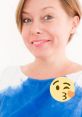 Smiling woman in a blue and white blouse, conveying a cheerful and friendly vibe with a playful emoji overlay.