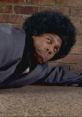 Character from "Chappelle's Show - Season 1," humorously pretending to be hurt while lying on the floor, dramatic expression.